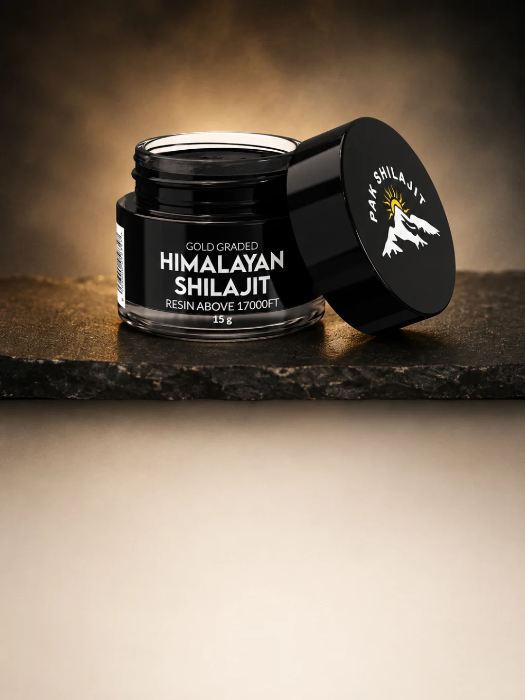 Open jar of gold-grade Himalayan shilajit resin with the steel spatula resting in the lid