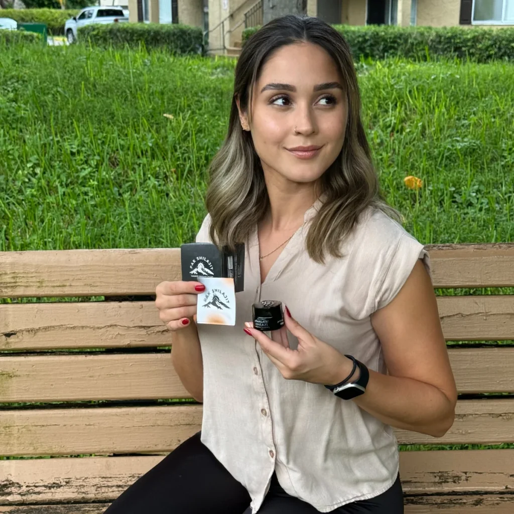 A Pak Shilajit customer holding a jar of shilajit resin outdoors